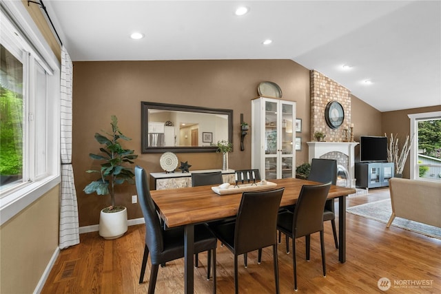 10811 164th Pl NE, Redmond, WA 98052 - dining space featuring wood finished floors, lofted ceiling, baseboards, a brick fireplace, and recessed lighting