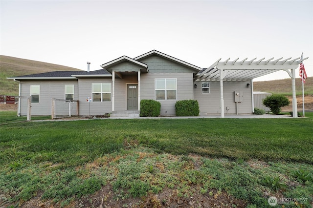 ranch-style home featuring a pergola and a front yard