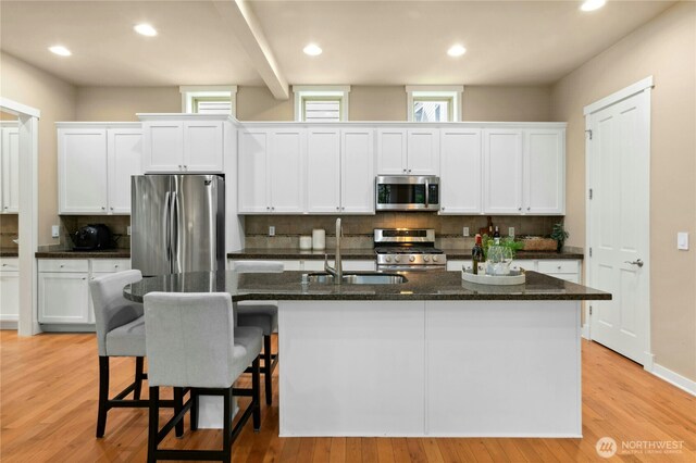 kitchen featuring appliances with stainless steel finishes, a sink, decorative backsplash, and recessed lighting