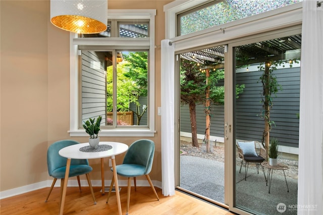 doorway to outside with wood finished floors and baseboards