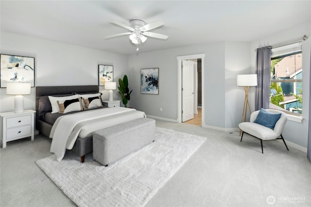 bedroom featuring light carpet, baseboards, and a ceiling fan