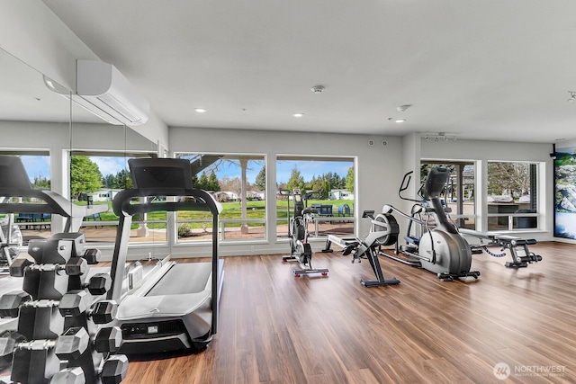 workout area featuring a wall mounted air conditioner, plenty of natural light, and recessed lighting