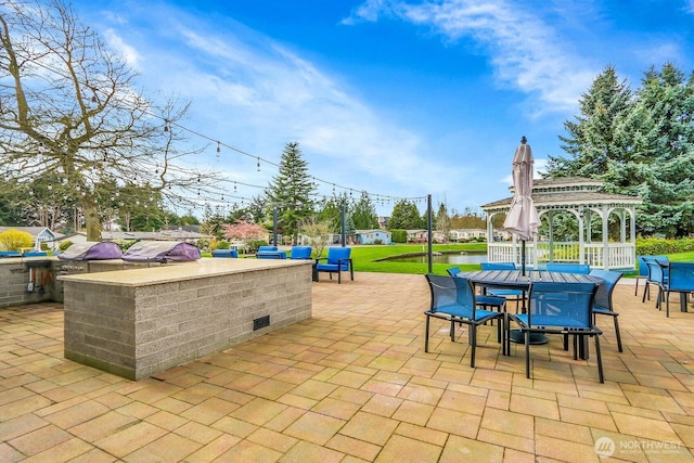 view of patio with outdoor dry bar, a gazebo, outdoor dining space, and grilling area