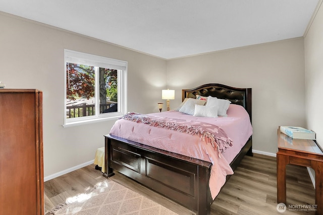 bedroom featuring baseboards and wood finished floors