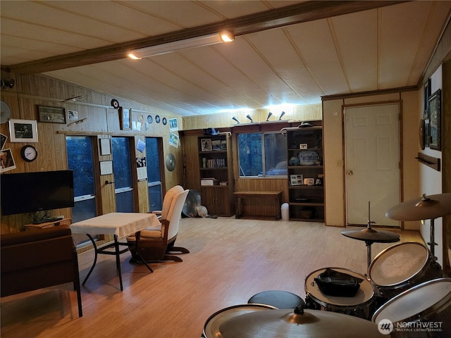 living room featuring wooden walls, wood finished floors, and lofted ceiling with beams