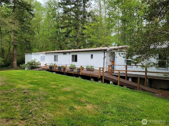 back of house featuring a wooden deck and a lawn