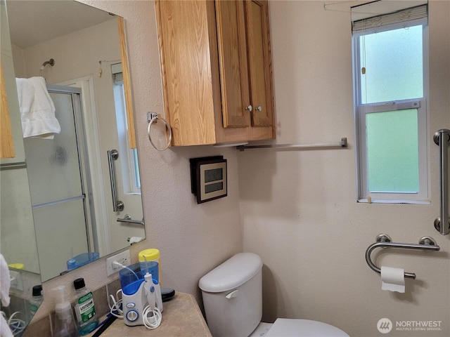 bathroom with a stall shower and toilet
