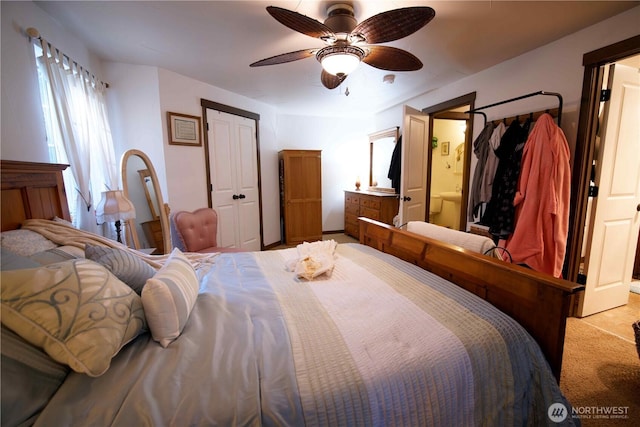 carpeted bedroom with ceiling fan, a closet, and ensuite bathroom