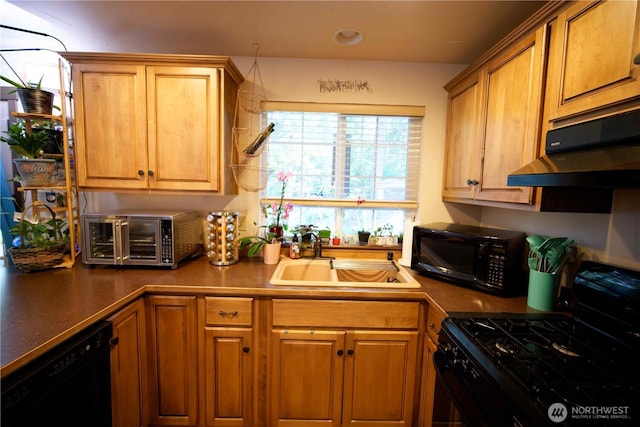 kitchen featuring black appliances, a sink, under cabinet range hood, dark countertops, and brown cabinetry