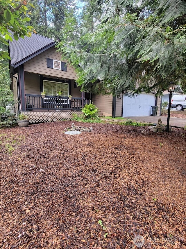 view of front of home with covered porch, a garage, driveway, and roof with shingles