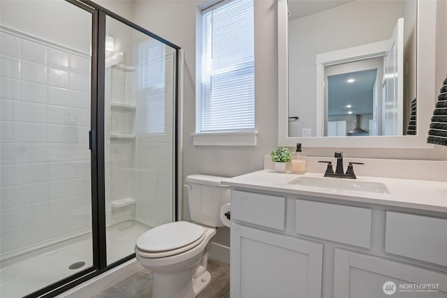 bathroom featuring toilet, a shower stall, healthy amount of natural light, and vanity