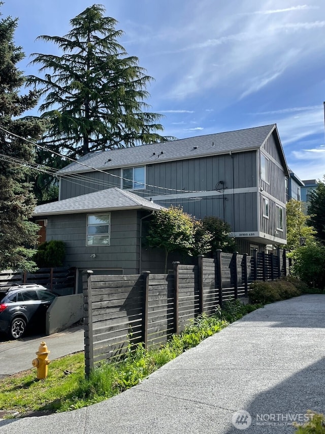 10202 1st Ave NW, Seattle, WA 98177 - view of property exterior featuring a shingled roof, fence, and board and batten siding