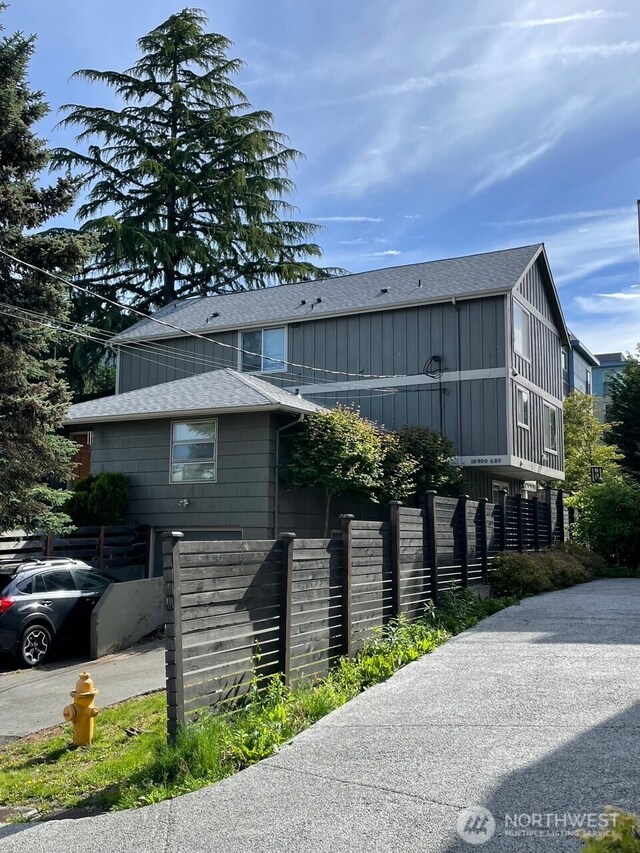 10202 1st Ave NW, Seattle, WA 98177 - view of property exterior featuring a shingled roof, fence, and board and batten siding