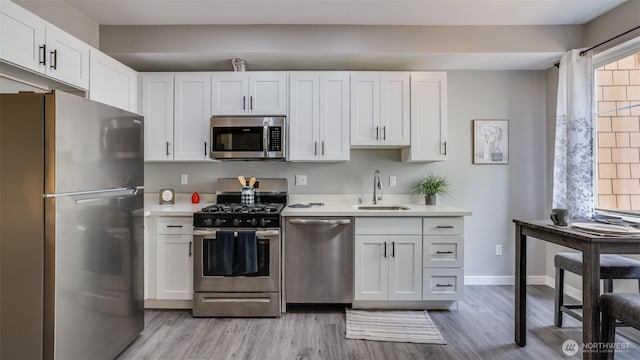 564 225th Ln NE Unit A-105, Sammamish, WA 98074 - kitchen with stainless steel appliances, light countertops, a sink, white cabinets, and light wood-style floors