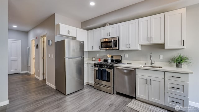 564 225th Ln NE Unit A-105, Sammamish, WA 98074 - kitchen with stainless steel appliances, a sink, recessed lighting, light countertops, and light wood finished floors