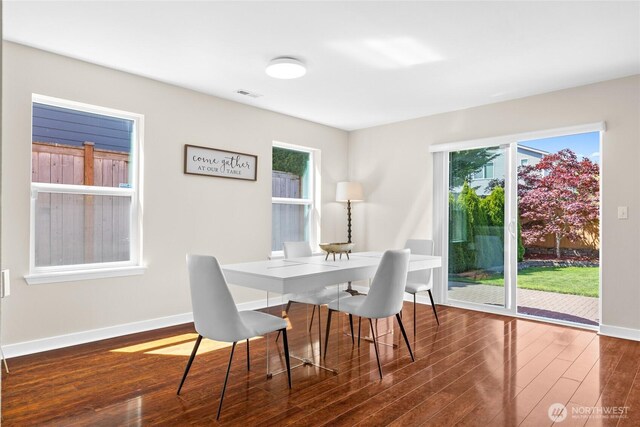dining room featuring dark wood-style flooring and baseboards