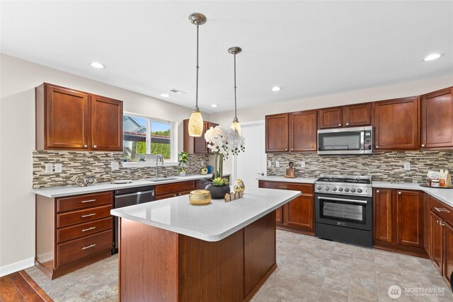 kitchen with appliances with stainless steel finishes, a sink, decorative backsplash, pendant lighting, and recessed lighting