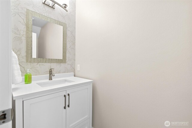 bathroom featuring wallpapered walls and vanity