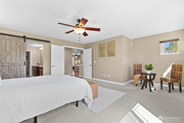 bedroom featuring a barn door, baseboards, carpet floors, and a ceiling fan