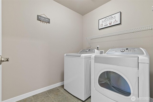 clothes washing area featuring washing machine and clothes dryer and baseboards