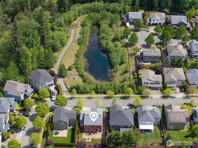 aerial view of property and surrounding area featuring nearby suburban area and a nearby body of water