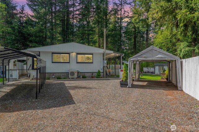 view of front facade with a carport, fence, and a cooling unit