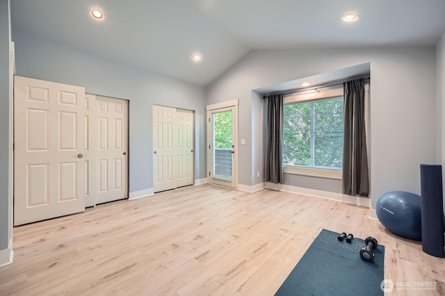 exercise area featuring light wood-style floors, vaulted ceiling, baseboards, and recessed lighting