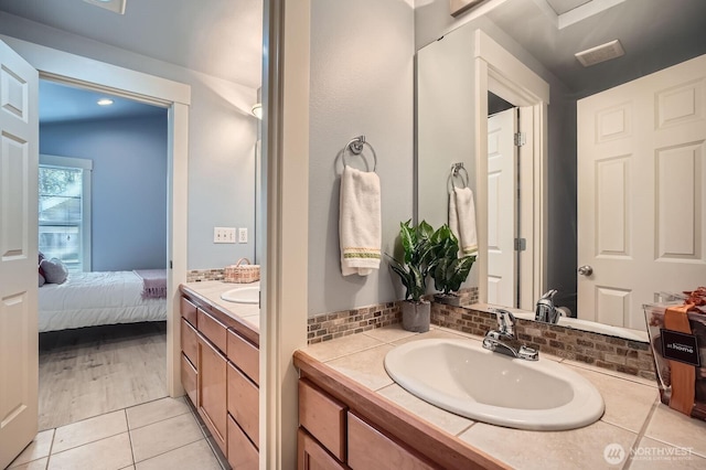 ensuite bathroom with vanity and tile patterned flooring