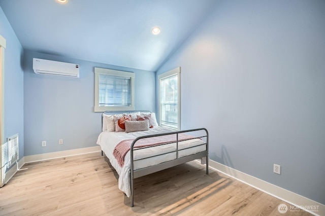 bedroom with a wall mounted air conditioner, light wood-type flooring, baseboards, recessed lighting, and lofted ceiling