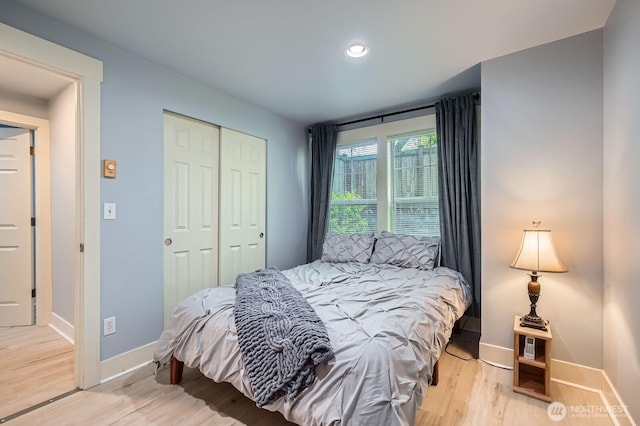 bedroom featuring light wood-style flooring, baseboards, a closet, and recessed lighting