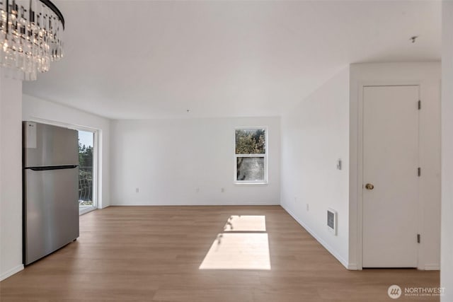 12050 15th Ave NE Unit 404, Seattle, WA 98125 - unfurnished living room with light wood-type flooring and baseboards