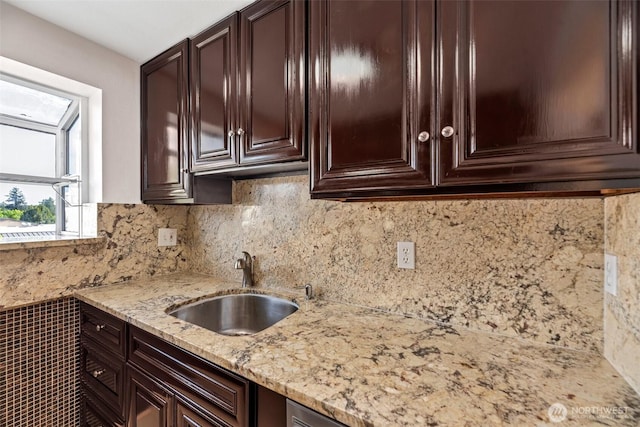 12050 15th Ave NE Unit 404, Seattle, WA 98125 - kitchen featuring a sink, light stone counters, dark brown cabinets, and decorative backsplash