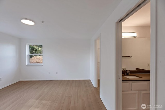 12050 15th Ave NE Unit 404, Seattle, WA 98125 - hall featuring a sink, light wood finished floors, and baseboards