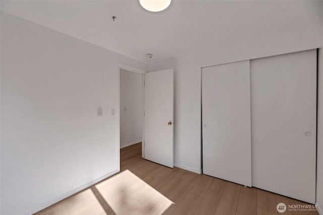 12050 15th Ave NE Unit 404, Seattle, WA 98125 - unfurnished bedroom with light wood finished floors and a closet