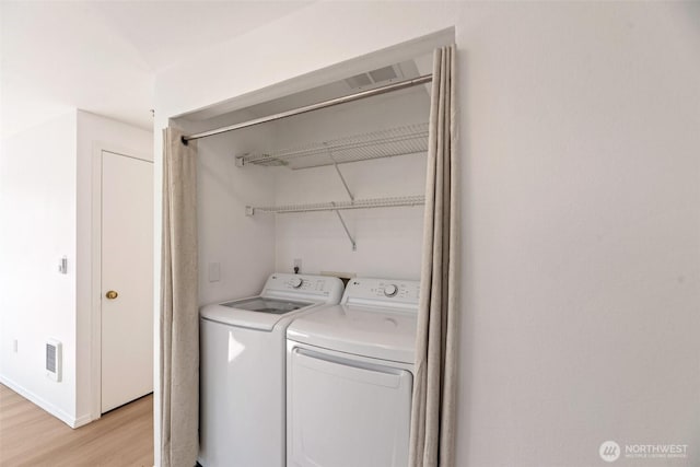 12050 15th Ave NE Unit 404, Seattle, WA 98125 - clothes washing area featuring washing machine and clothes dryer, light wood-style flooring, and baseboards