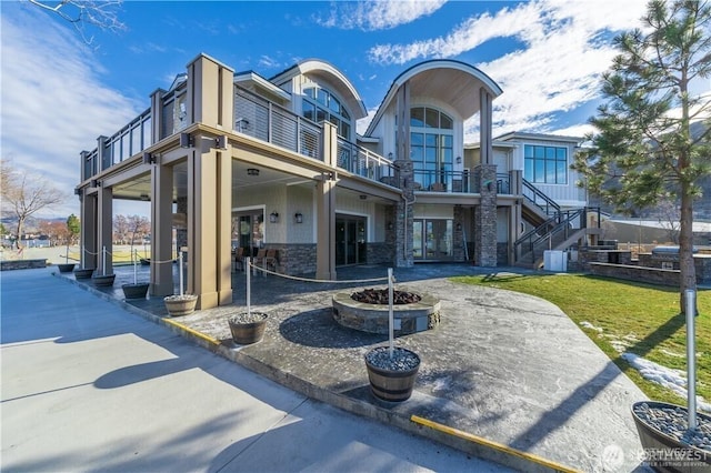 1350 W Woodin Ave, Chelan, WA 98816 - back of house with a balcony, a yard, a patio, stairs, and stone siding