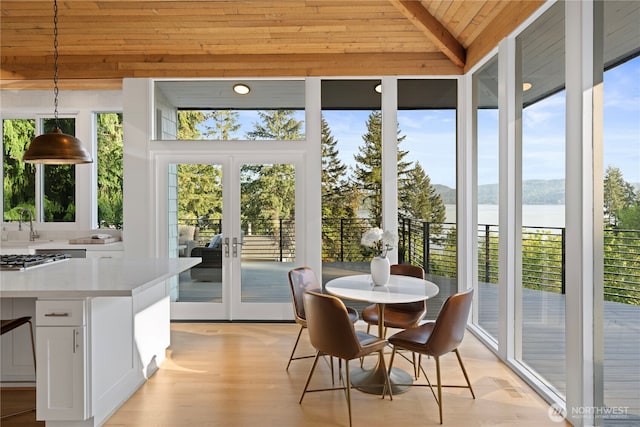 sunroom / solarium with french doors and a water view