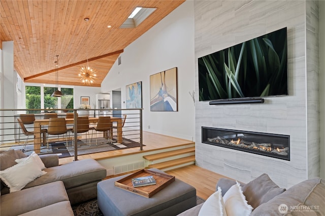 living area with wood ceiling, a tile fireplace, wood finished floors, baseboards, and high vaulted ceiling