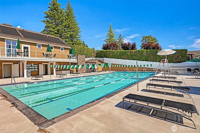 community pool with fence and a patio