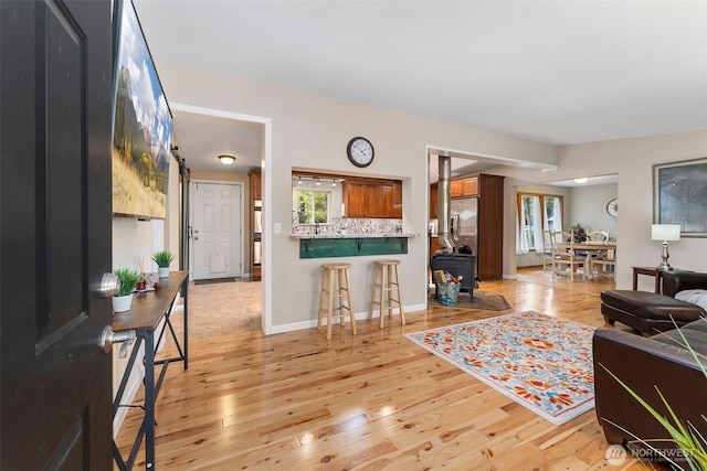 26911 312th Ave SE, Ravensdale, WA 98051 - living room with baseboards, a wood stove, and light wood-style flooring