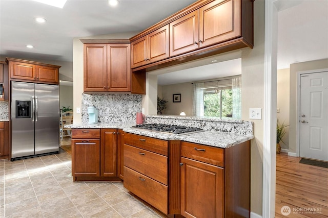 26911 312th Ave SE, Ravensdale, WA 98051 - kitchen with brown cabinets, stainless steel appliances, decorative backsplash, light stone counters, and recessed lighting