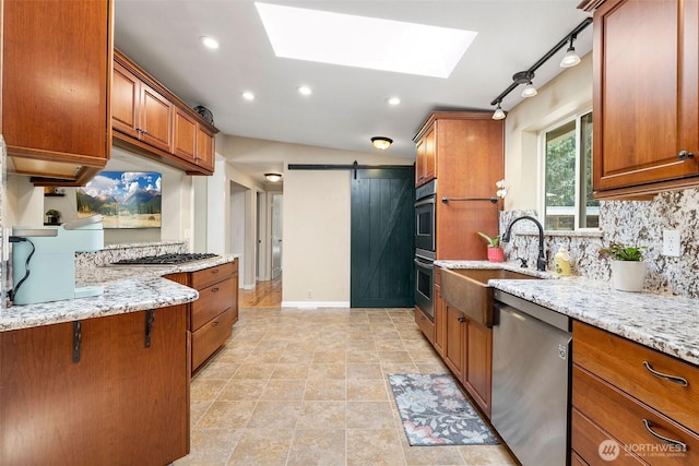 26911 312th Ave SE, Ravensdale, WA 98051 - kitchen with brown cabinetry, a barn door, appliances with stainless steel finishes, and a skylight