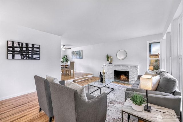 12219 SE 64th Pl, Bellevue, WA 98006 - living area with light wood finished floors, a ceiling fan, baseboards, and a fireplace