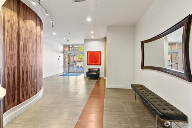 hallway with tile patterned floors, recessed lighting, and baseboards