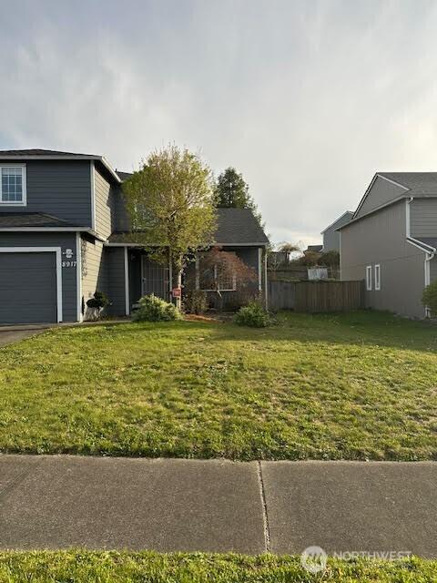view of front facade featuring a front lawn and fence