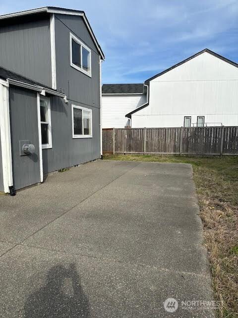 view of side of home featuring fence and a patio