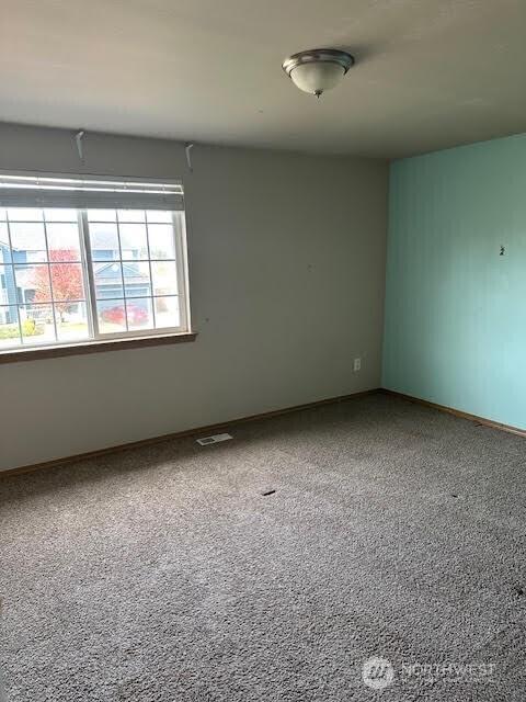 spare room featuring baseboards and visible vents