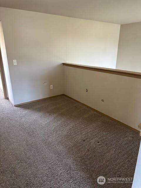 carpeted empty room featuring baseboards
