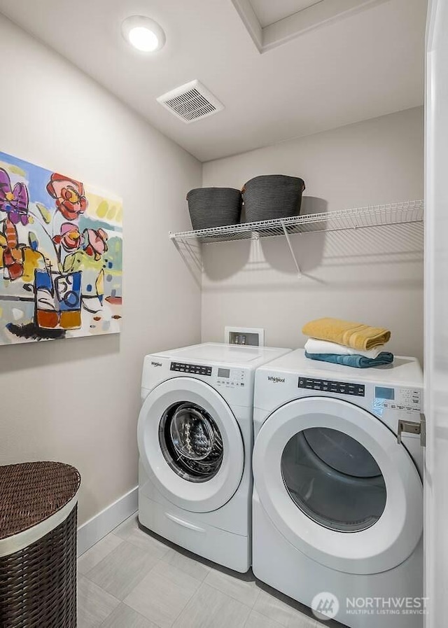 laundry room featuring washing machine and clothes dryer, baseboards, laundry area, and visible vents