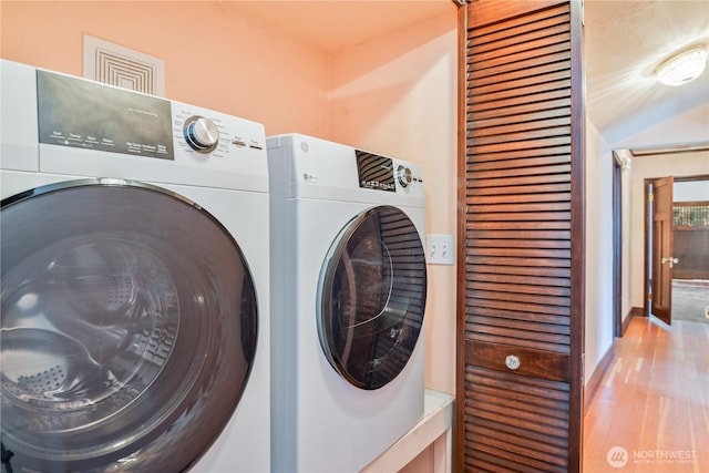 1639 21st Ave, Longview, WA 98632 - laundry area with washer and dryer, wood finished floors, and baseboards